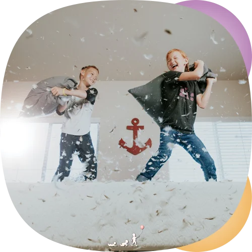 Two boys having a pillow fight with feathers in the air: play, senses and sensory integration